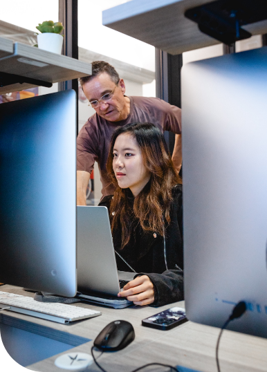 a student and a teacher looking at a computer